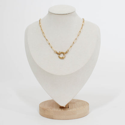 Gold front clasp necklace on a white mannequin bust with a white background