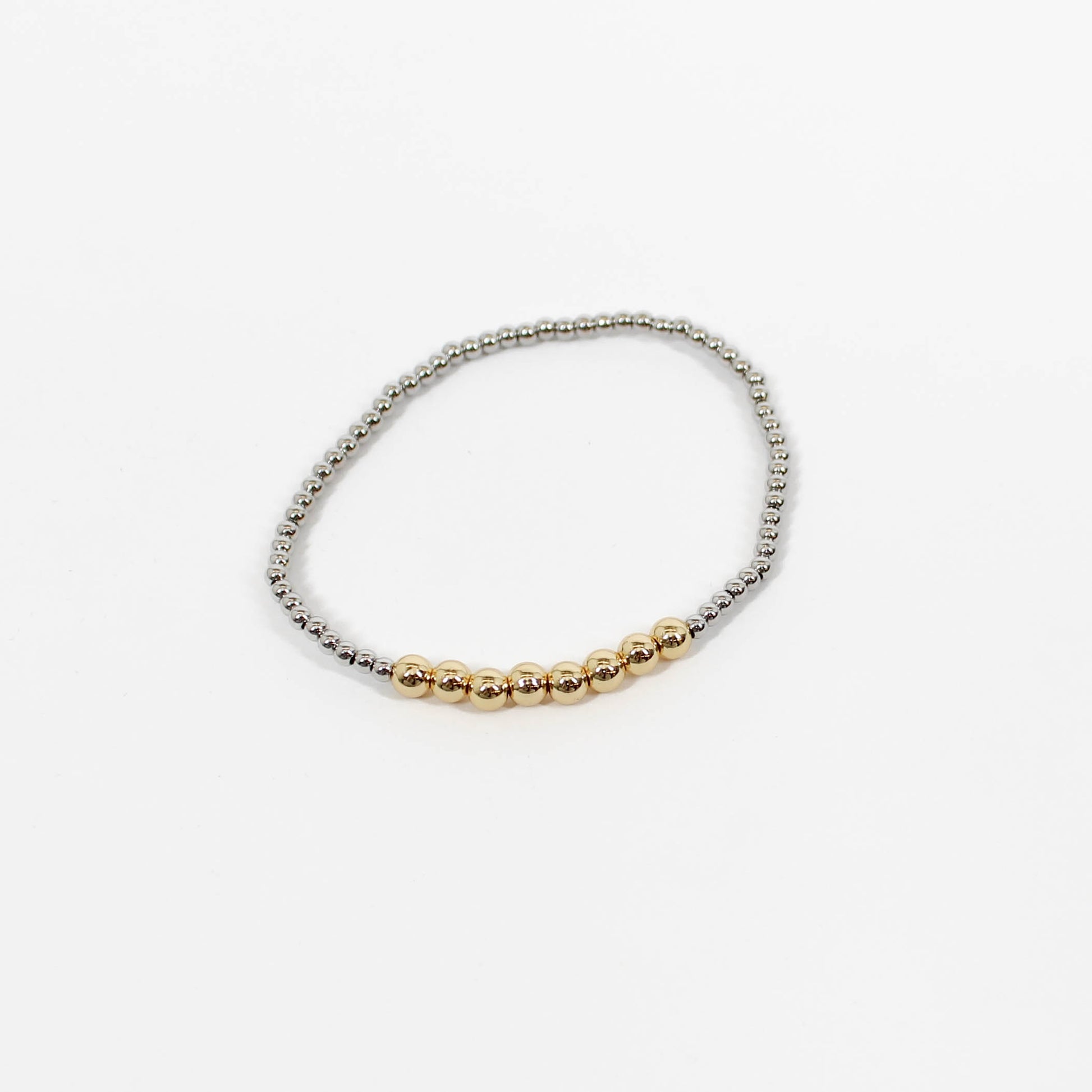 Bracelet with gold and silver beads on a white background
