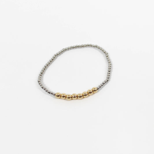 Bracelet with gold and silver beads on a white background