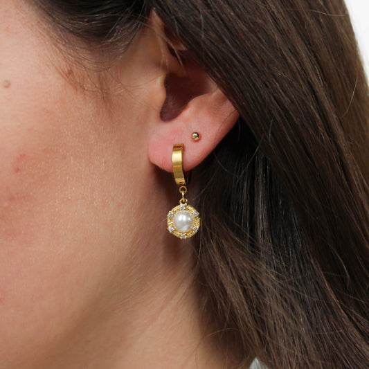Gold halo pearl drop earrings on ear