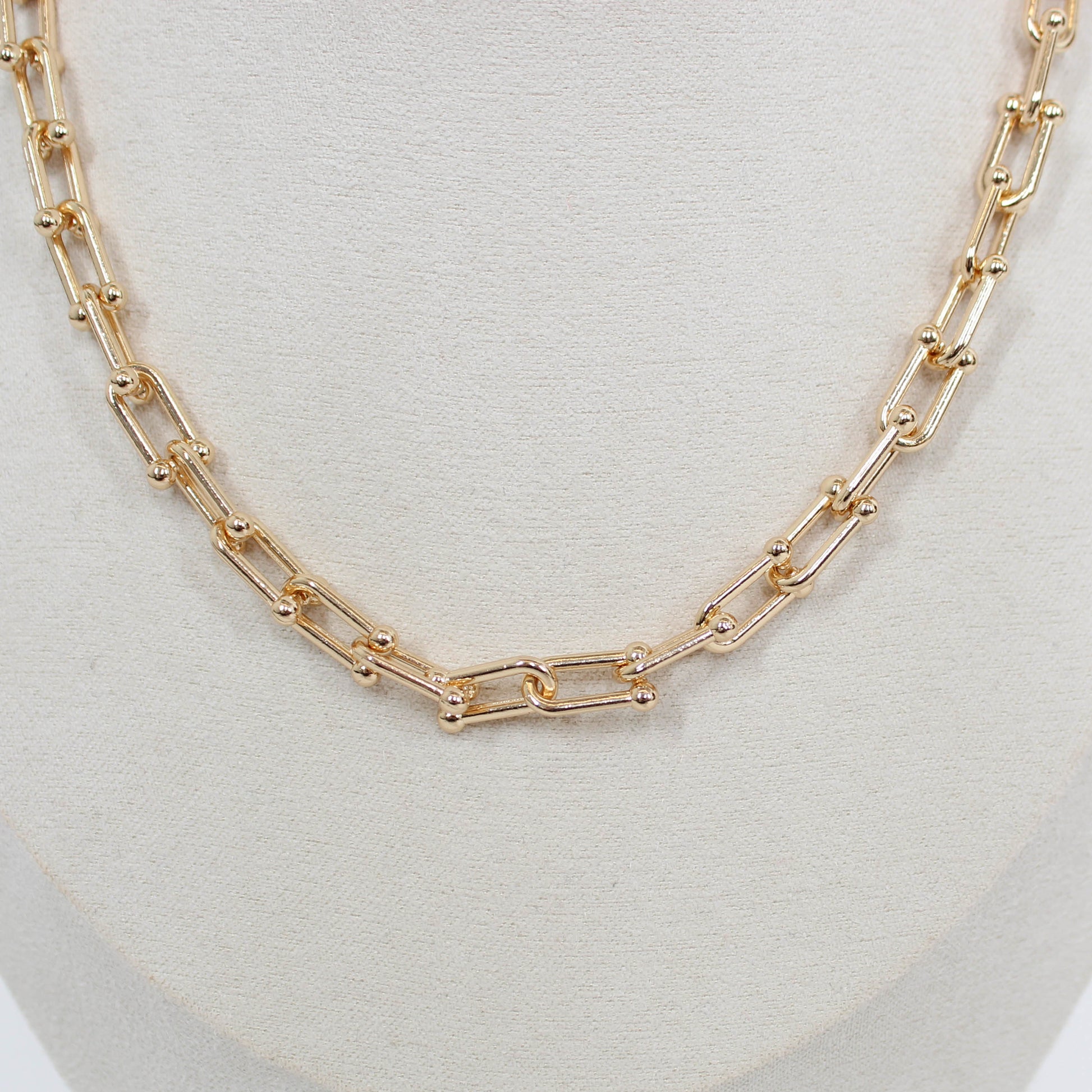 Gold chain hardware necklace on a white background