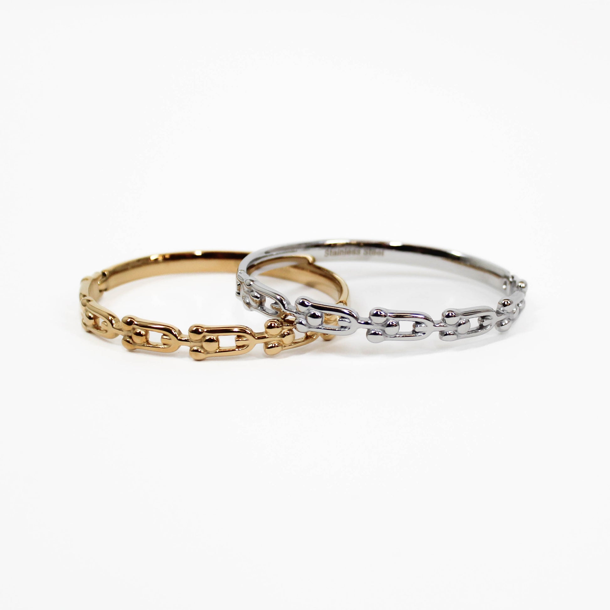 Two chain-link industrial link hinged bangle bracelets, one gold and one silver, on a white background.
