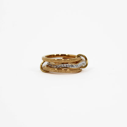 Gold interlocking link ring with embedded diamonds on a white background