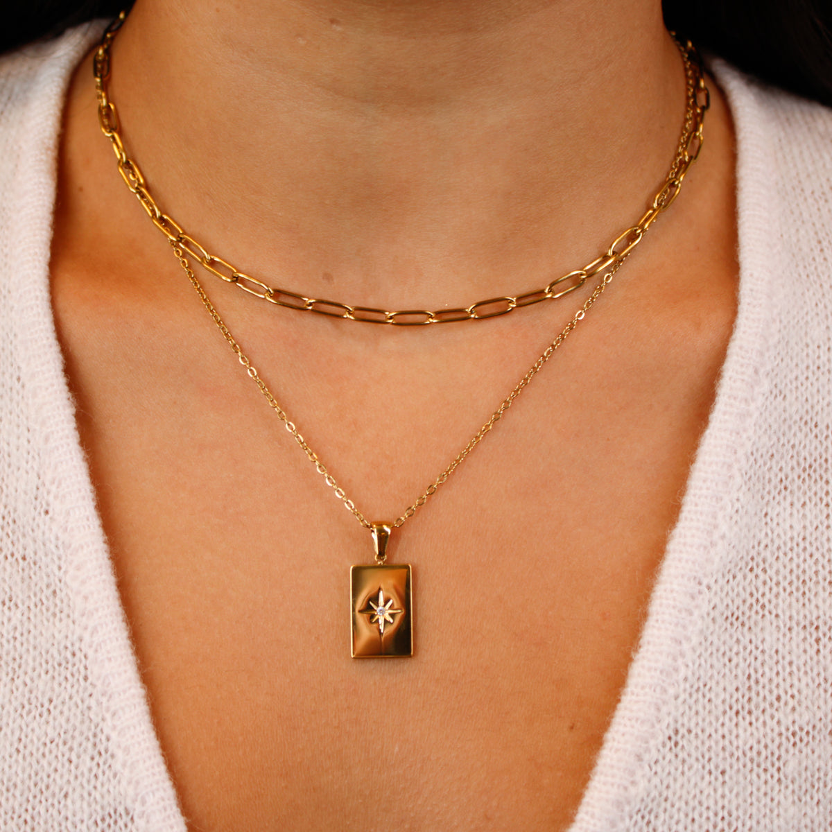 gold link chain necklace and gold chain necklace with pendant on model close up