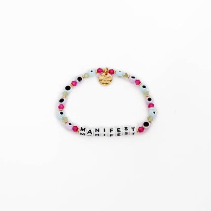 Little Words Project Bracelet with colorful beads and 'MANIFEST' charm on a white background