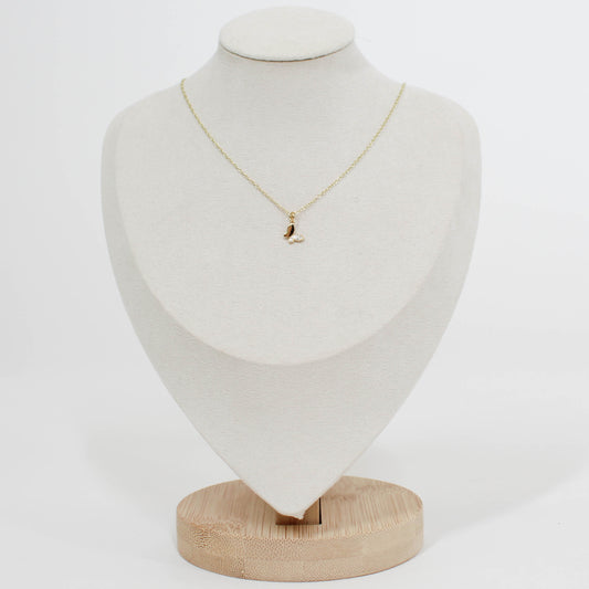 Gold necklace with a small butterfly pendant on a white mannequin bust.