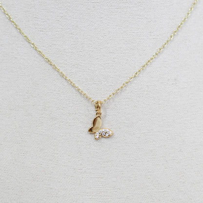 Gold butterfly necklace with a small pendant on a white background
