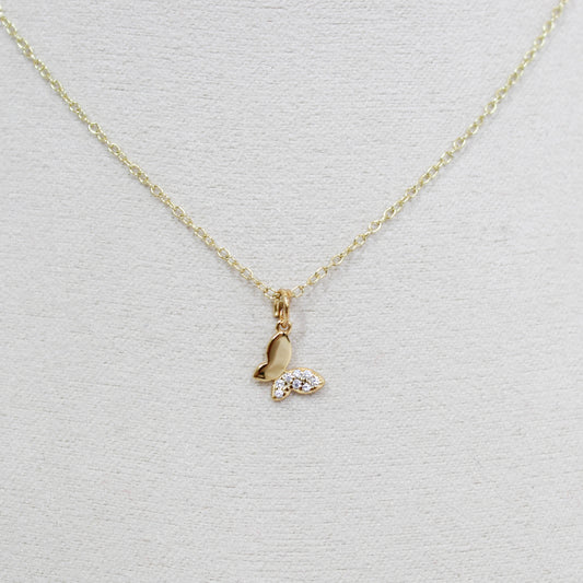 Gold butterfly necklace with a small pendant on a white background