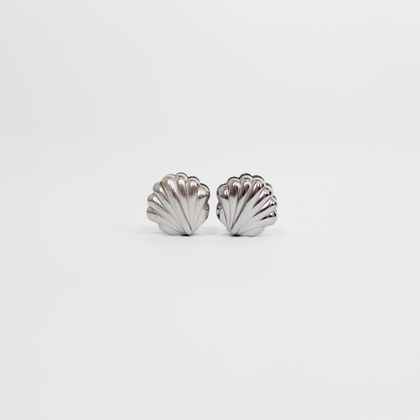 silver shell-shaped earrings on a white background