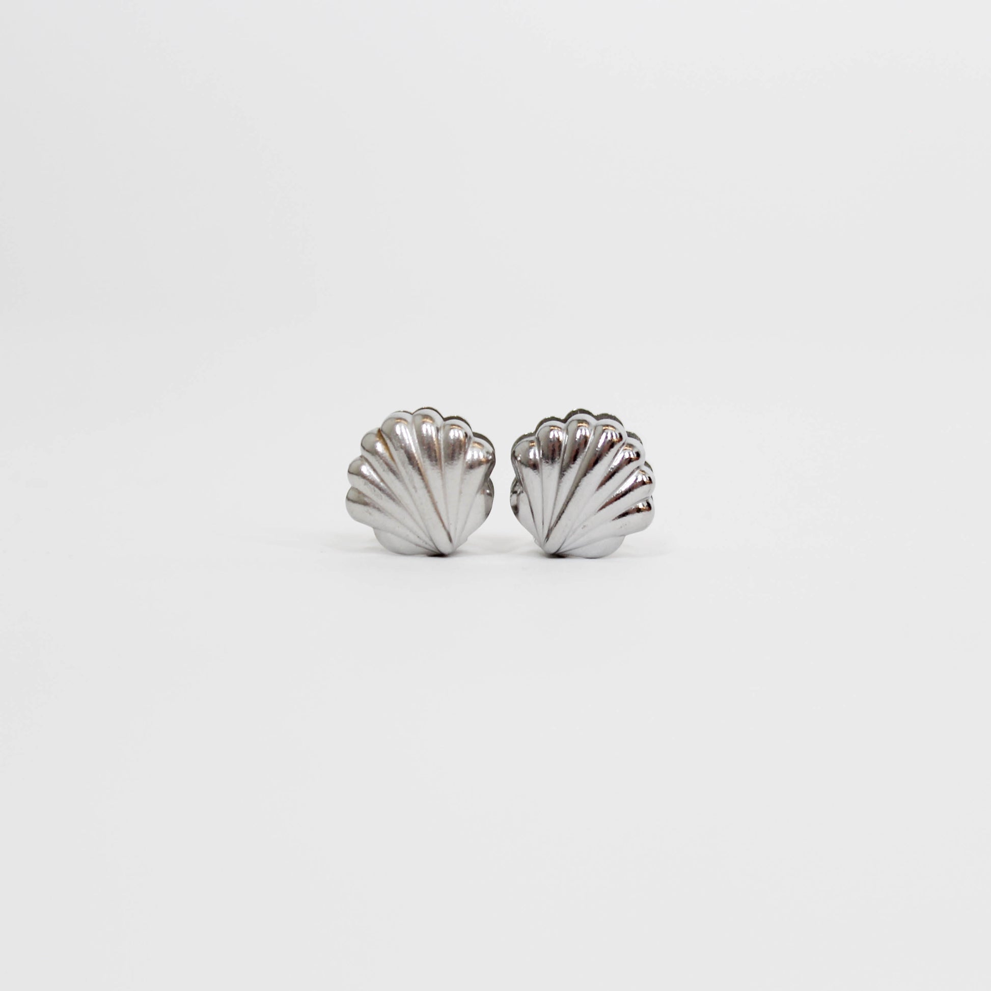 silver shell-shaped earrings on a white background