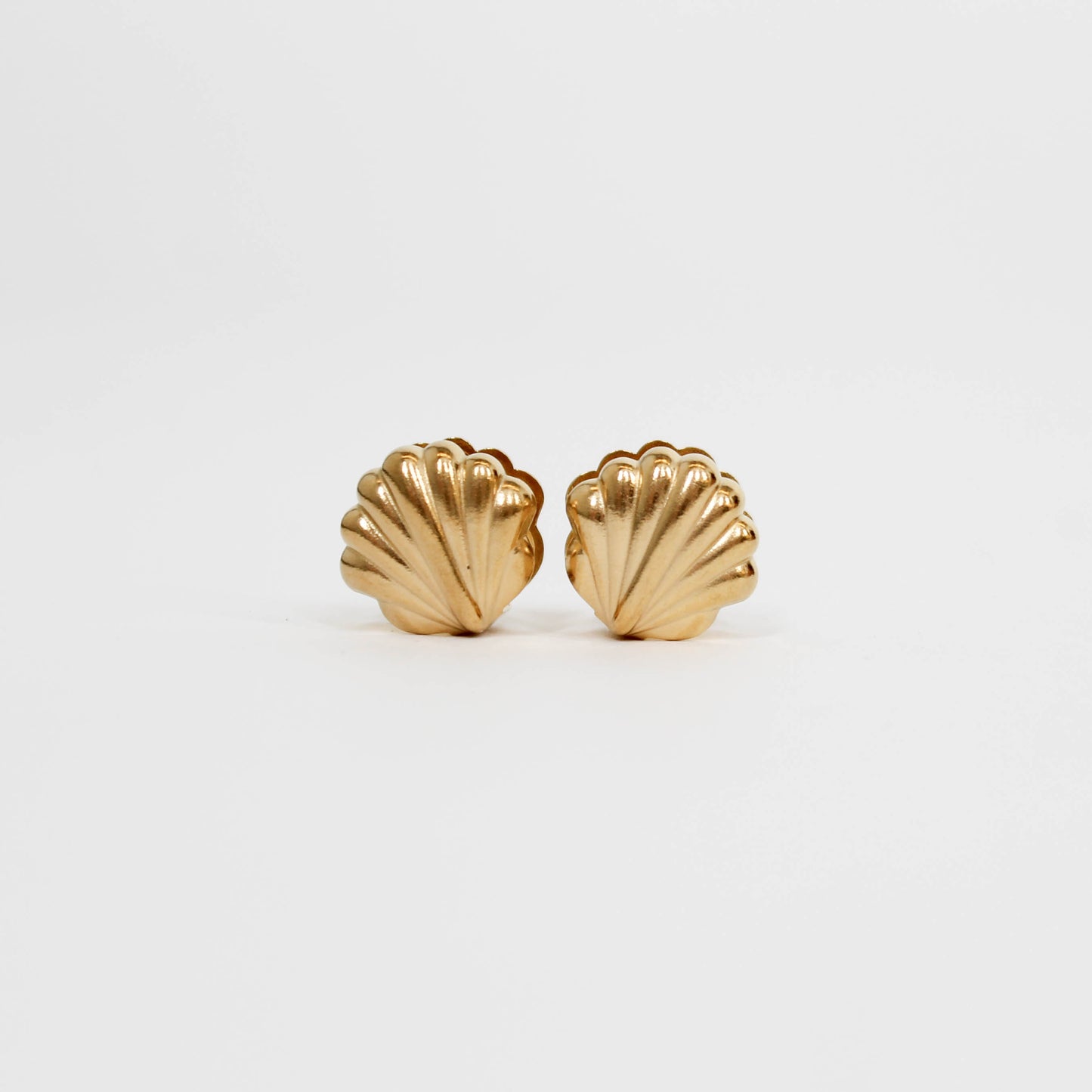 Gold shell-shaped earrings on a white background