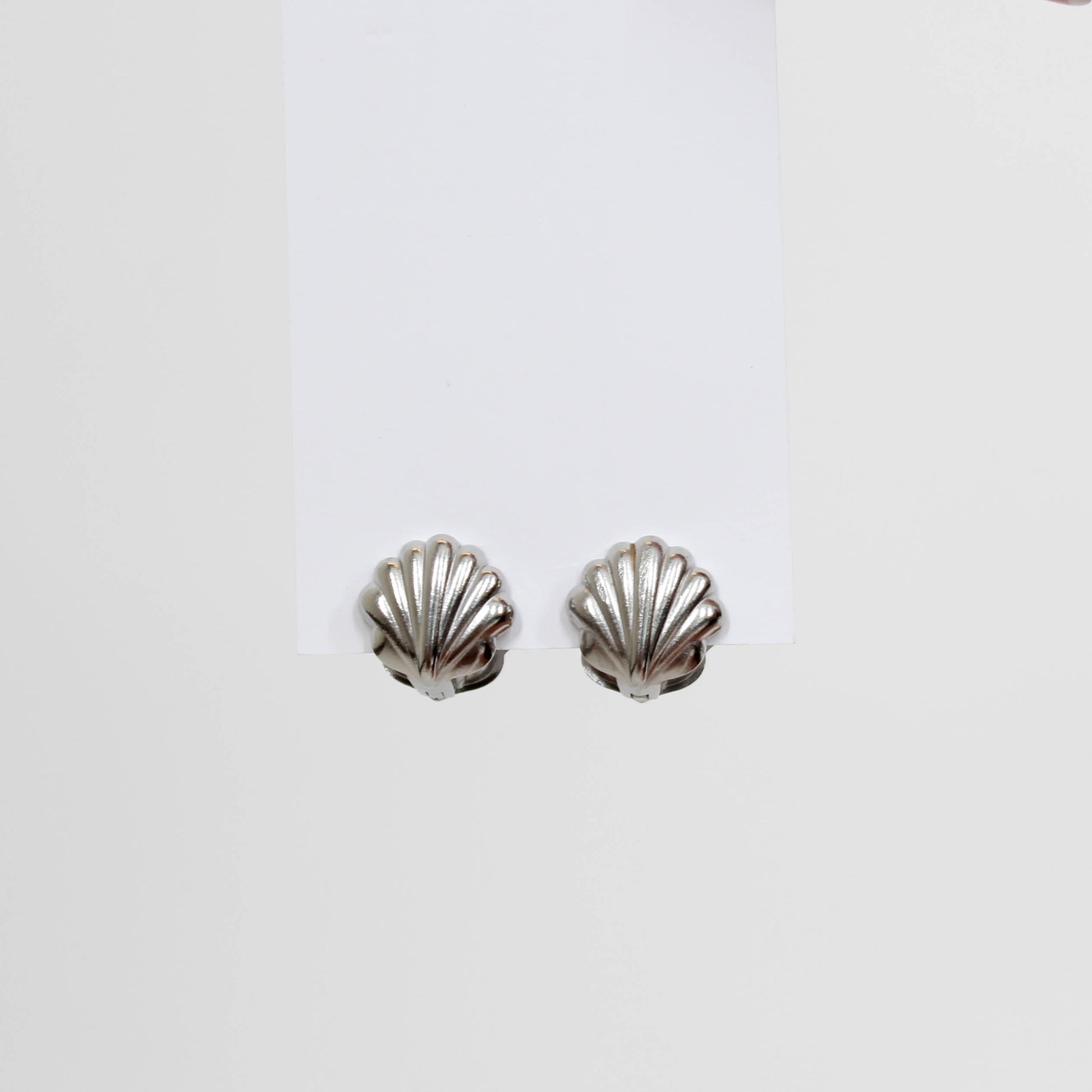 Silver shell-shaped earrings on a white background