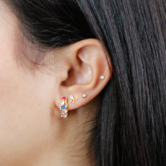 Close up of Multicolor Cluster Huggie Earrings on a model