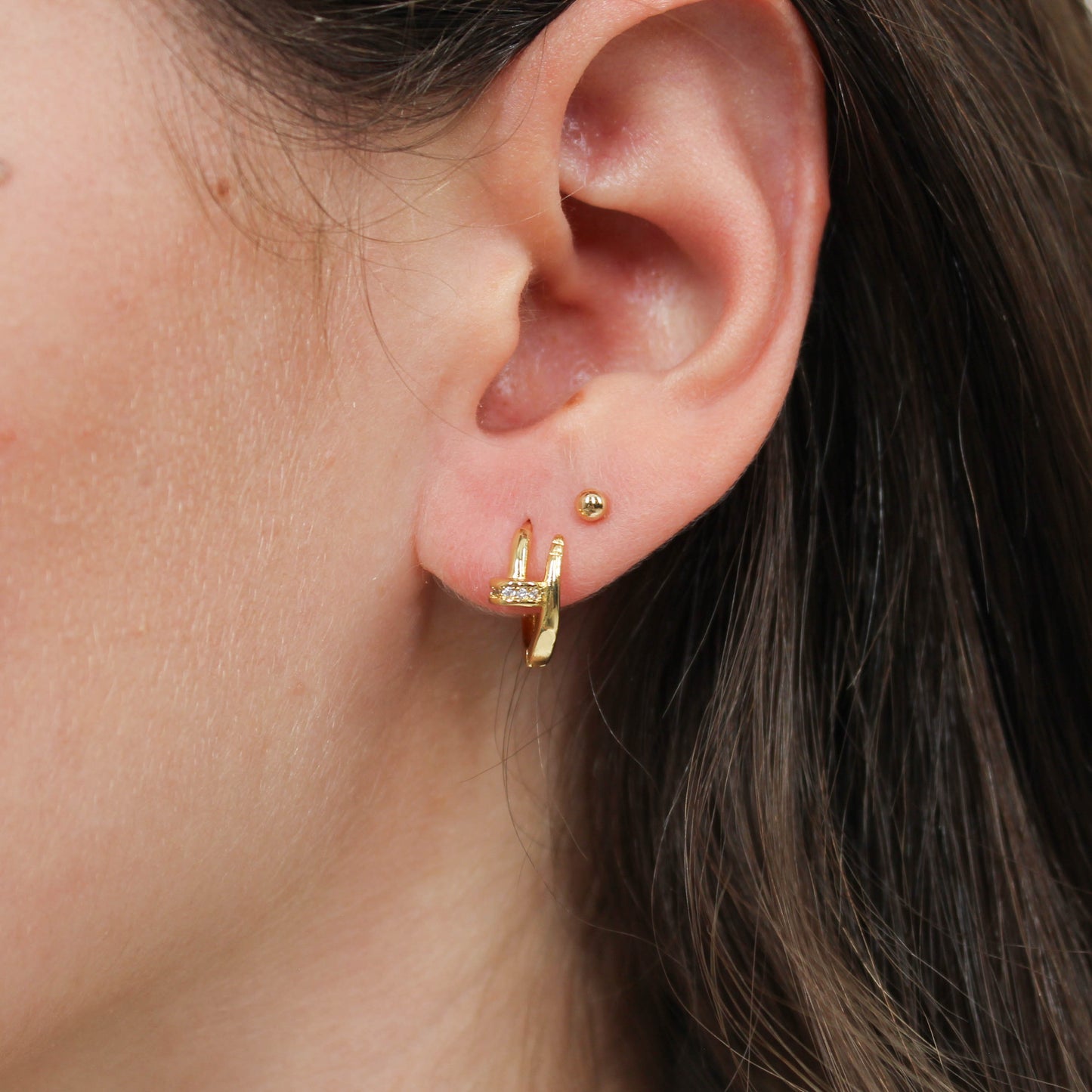 Nail huggie earring gold on ear 