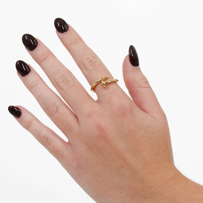 Gold nail ring on a hand with a white background 