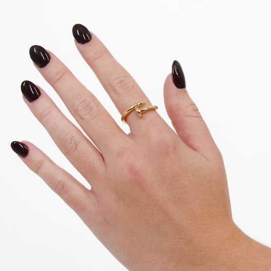 Gold nail ring on a hand with a white background 