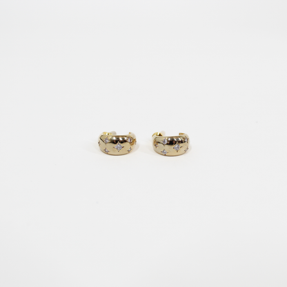 Gold northern stars hoop earrings with embedded stones on a white background