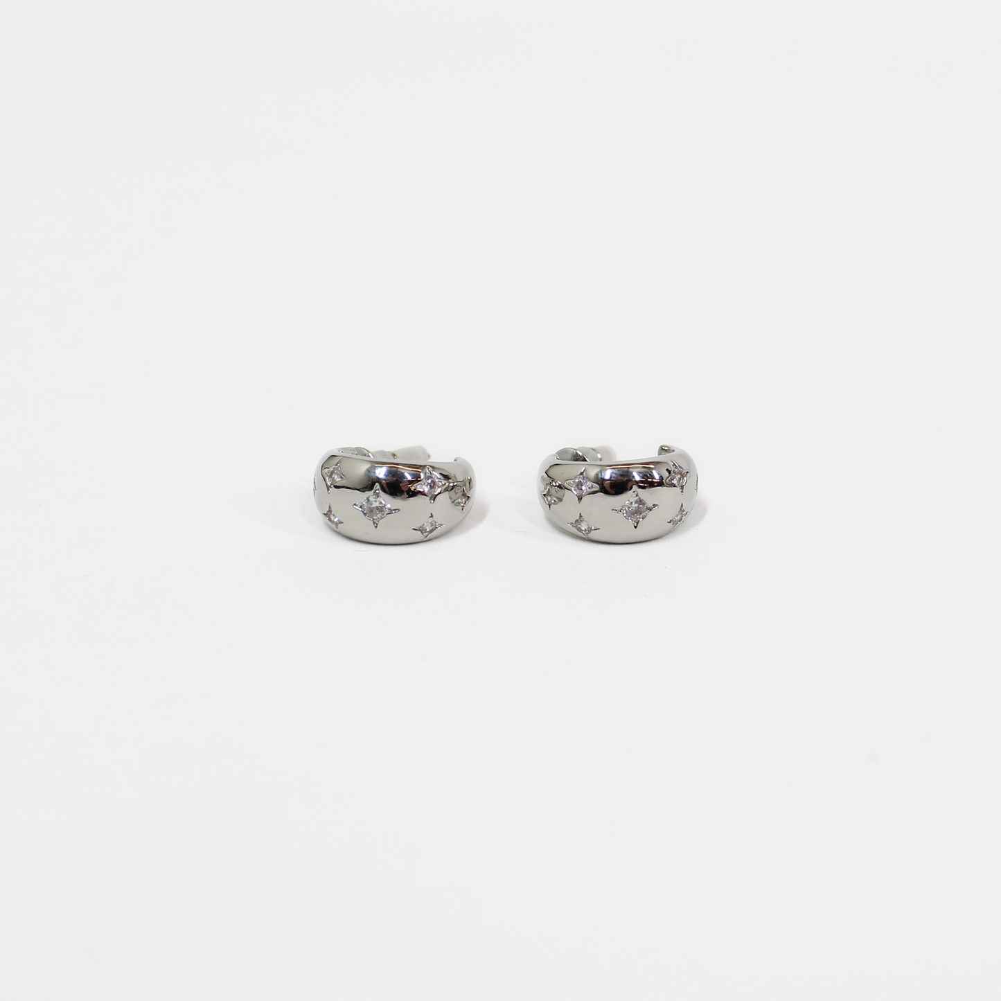 Pair of silver northern stars hoop earrings with embedded stones on a white background