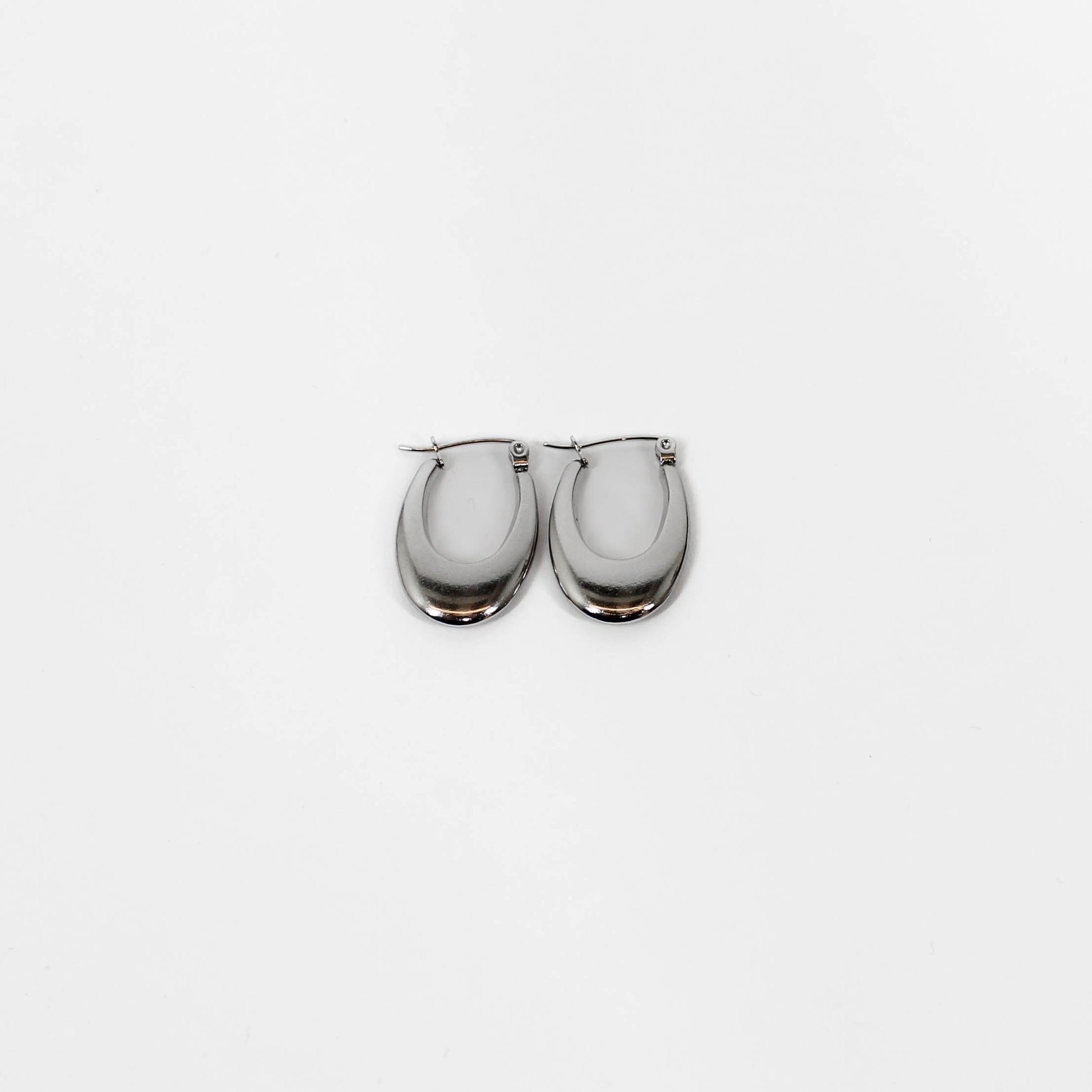 Pair of silver oblong latch hoop earrings on a white background