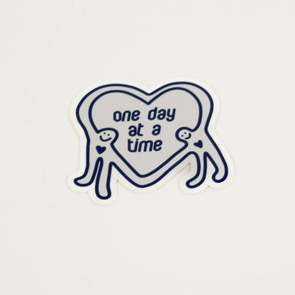 Heart-shaped sticker with 'one day at a time' text 
