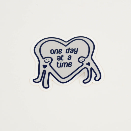 Heart-shaped sticker with 'one day at a time' text 