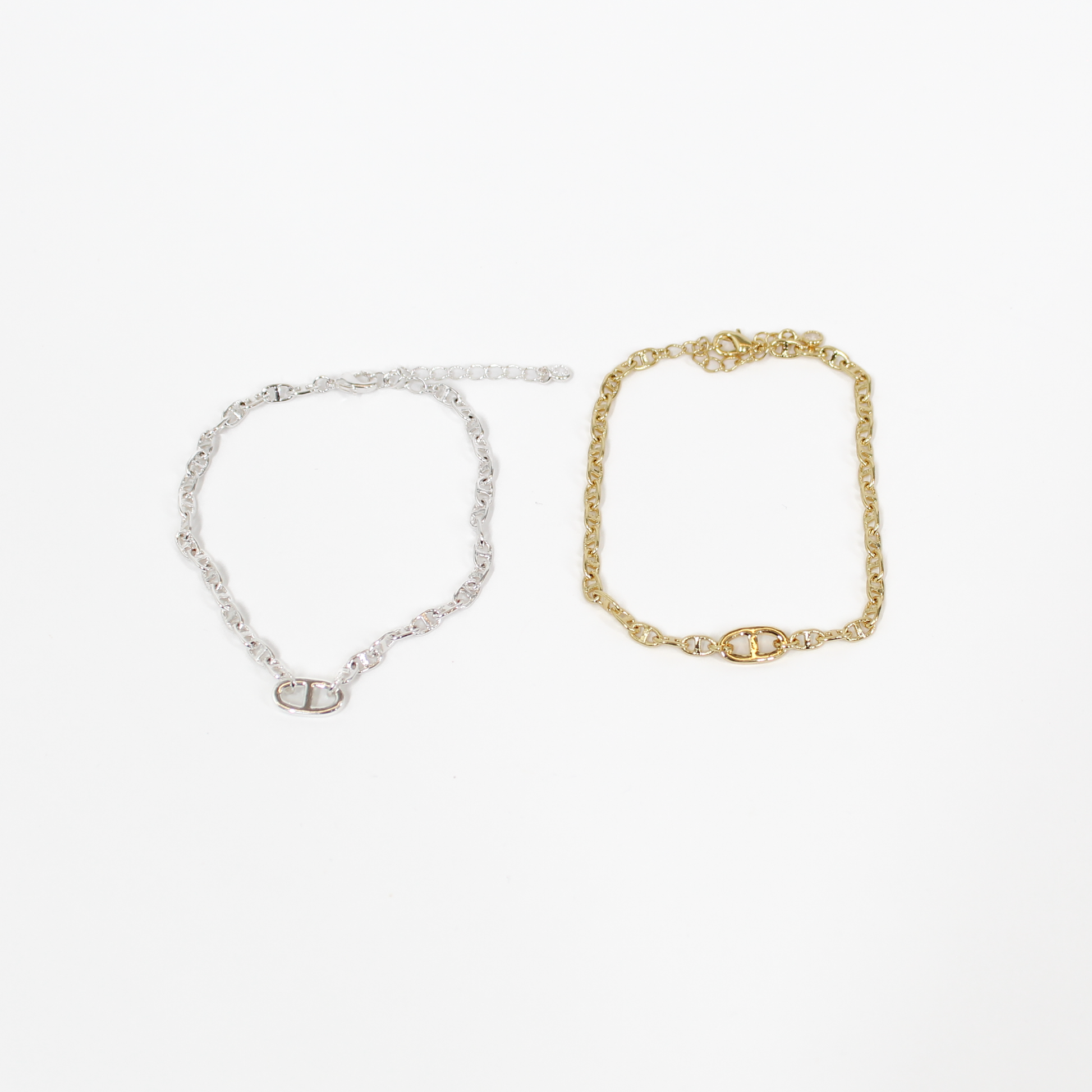 Gold and silver oval link chan bracelets on a white background
