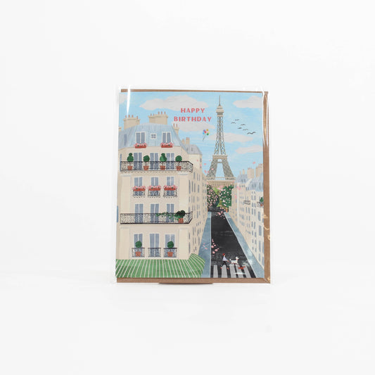 Greeting card with a Parisian street scene and Eiffel Tower, featuring 'Happy Birthday' text.