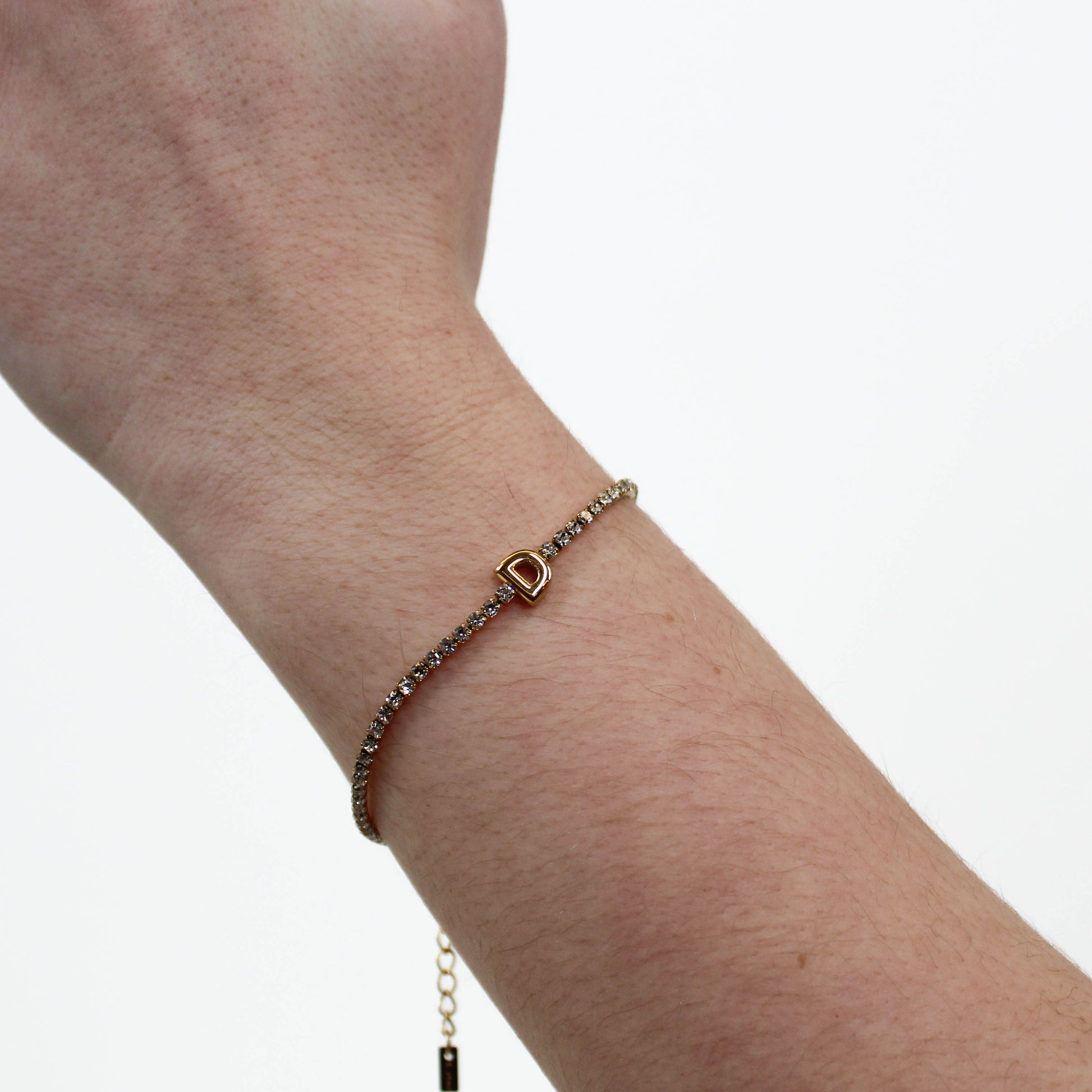 Rhinestone Letter Bracelet D on a wrist with a plain background
