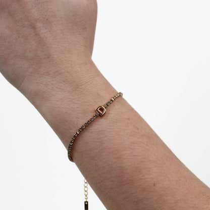 Rhinestone Letter Bracelet D on a wrist with a plain background