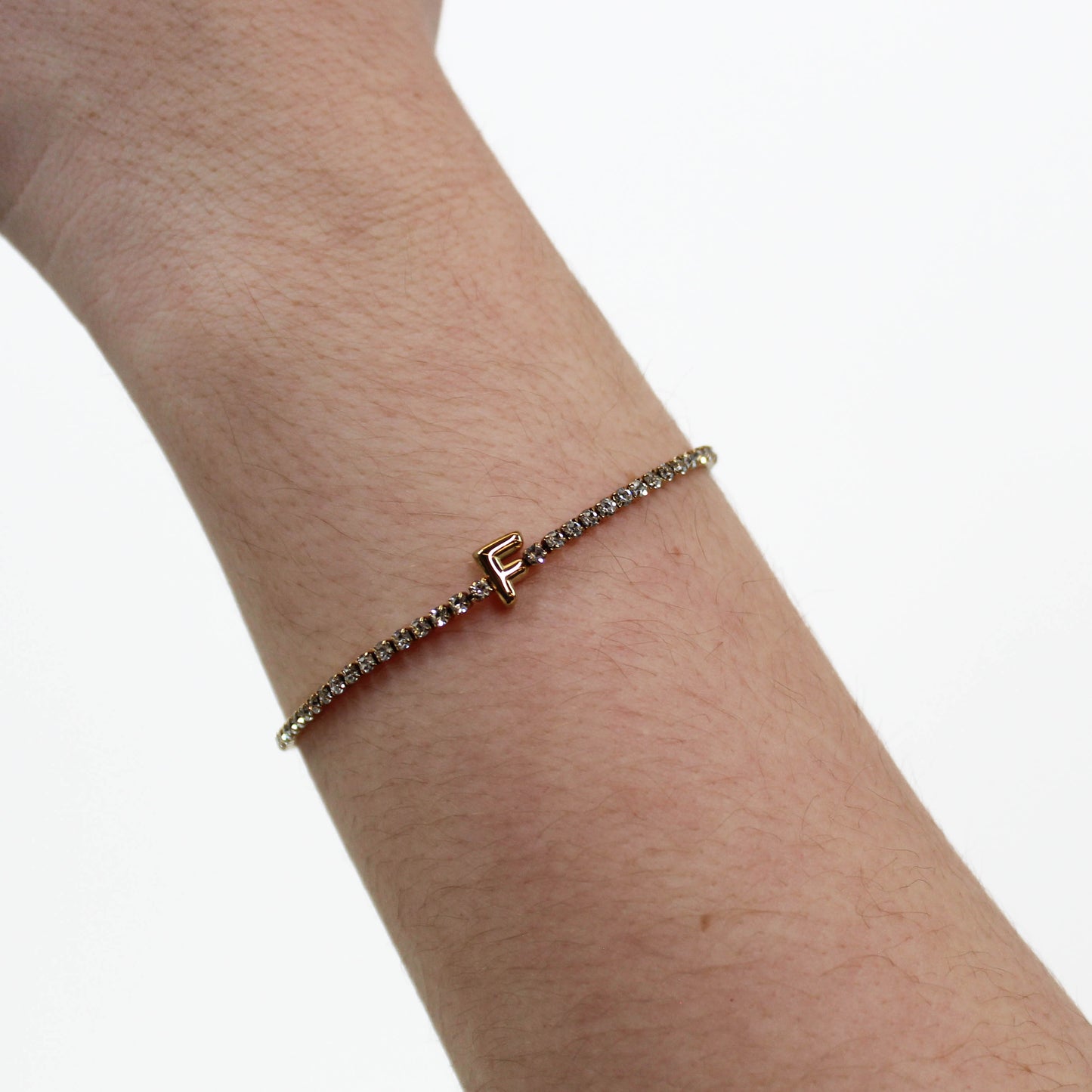 Rhinestone Letter Bracelet F on a wrist with a white background