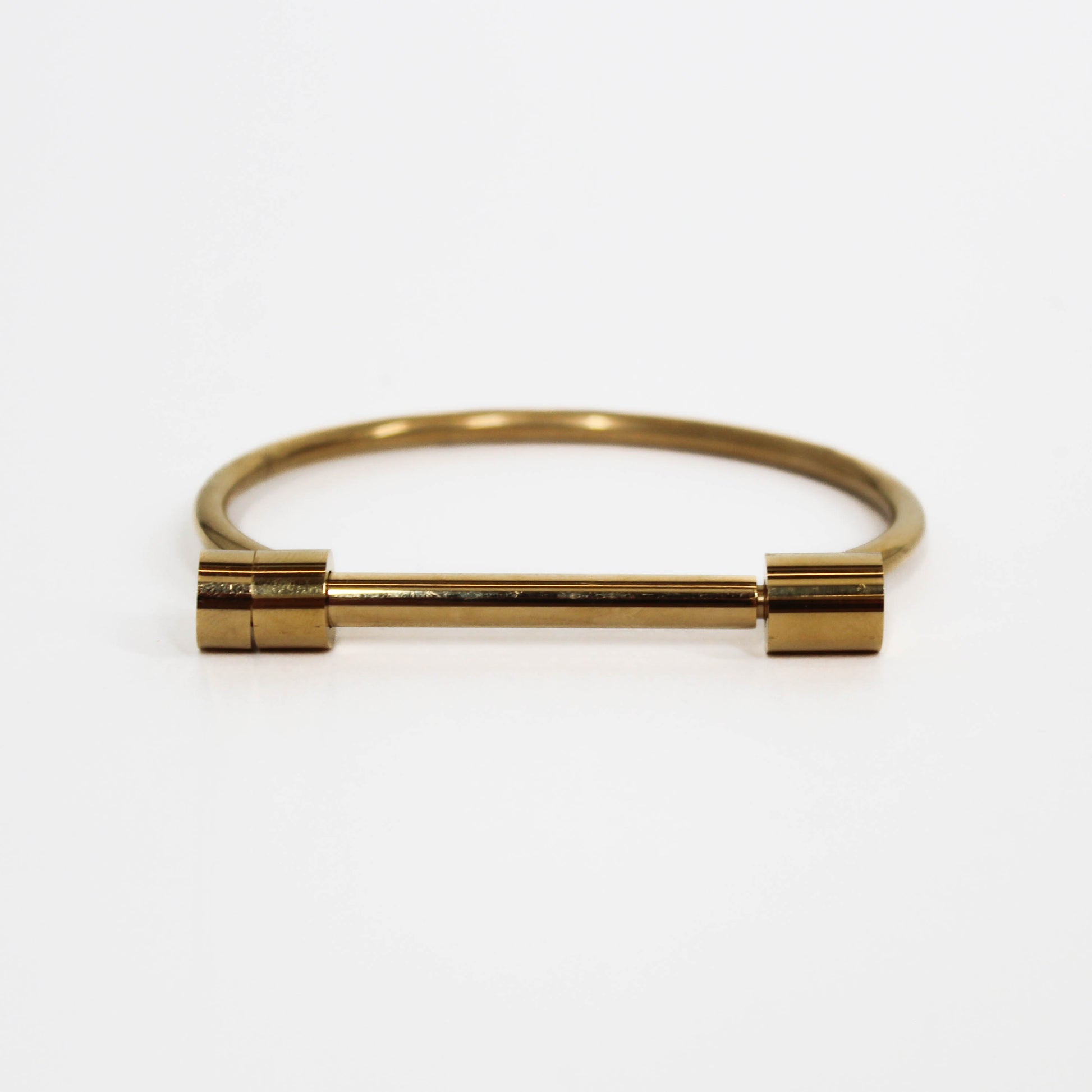 Gold screw cuff bracelet on a white background
