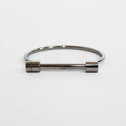Silver cylindrical screw cuff bracelet on a white background