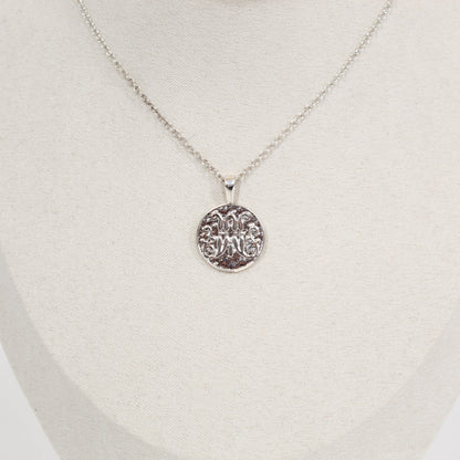 Silver scripted M Disc necklace for Marist on a white mannequin bust