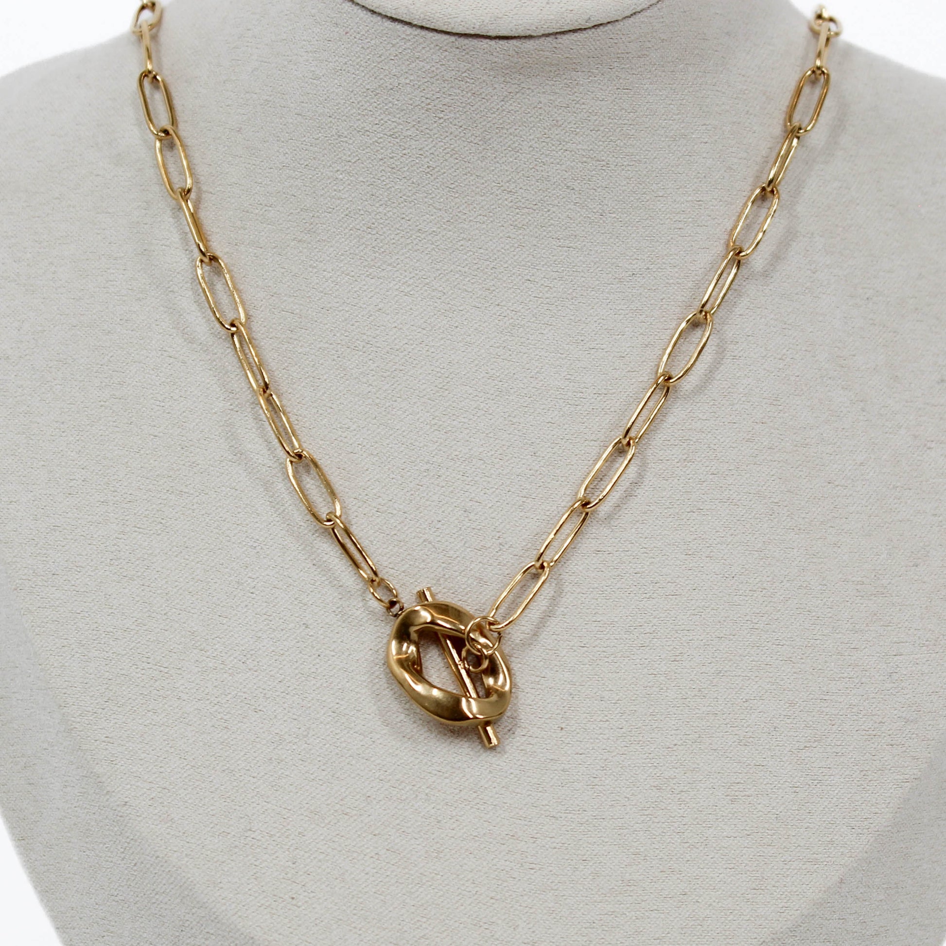 Gold chain sculpted toggle necklace with a unique clasp on a mannequin bust.