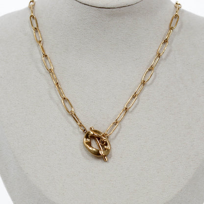 Gold chain sculpted toggle necklace with a unique clasp on a mannequin bust.