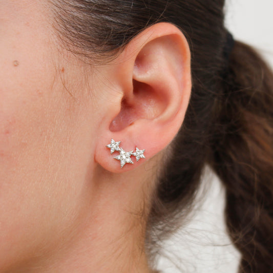 Close-up of an ear wearing shooting star-shaped earrings 