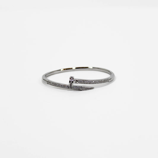 Silver nail bangle bracelet on a white background