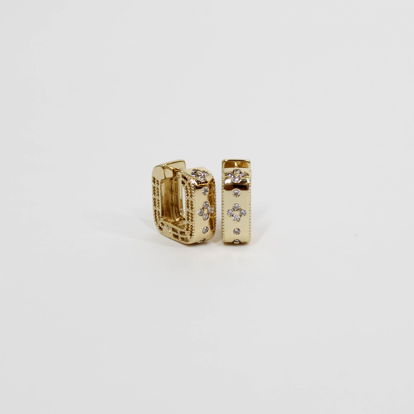 Gold hoop earrings with embedded geometric stones on a white background