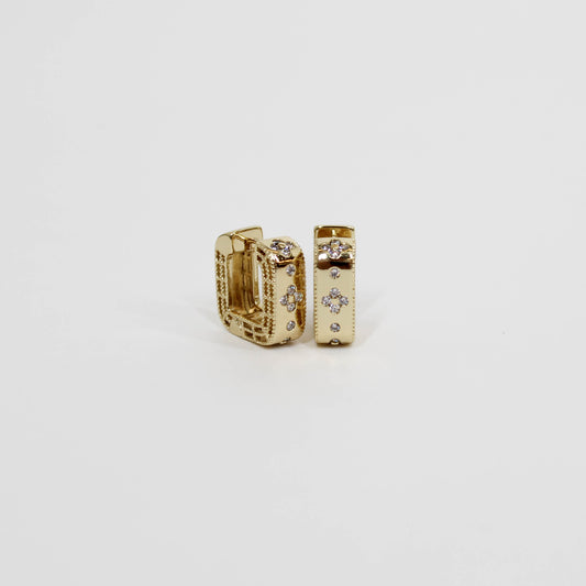 Gold hoop earrings with embedded geometric stones on a white background
