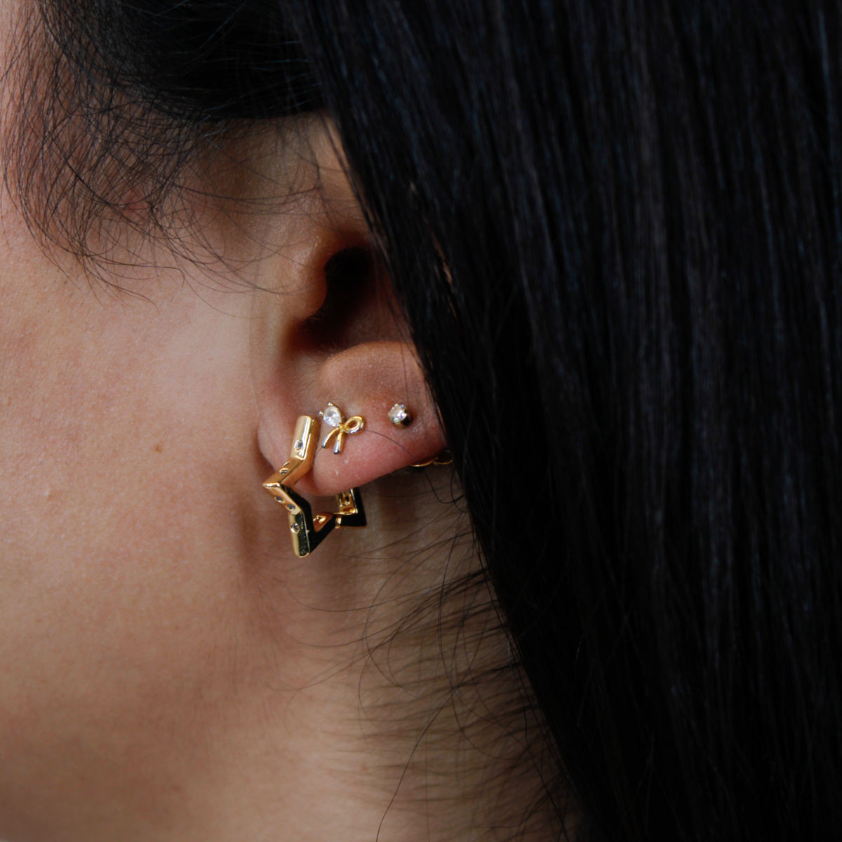 Close up of Star Huggie Earrings on model