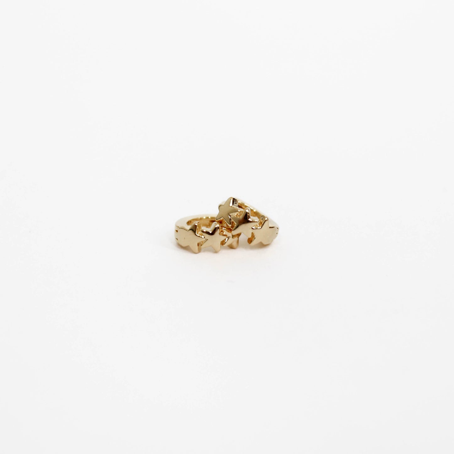 Gold Star huggie earrings on a white background. 