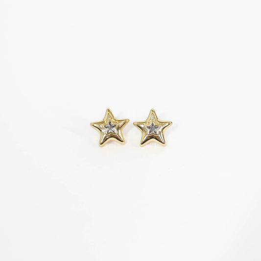 Gold star-shaped statement earrings with embedded stones on a white background