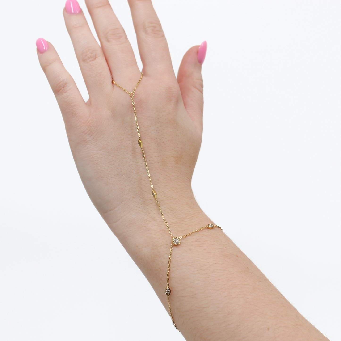 Gold stone charm hand chain bracelet on a hand against a white background