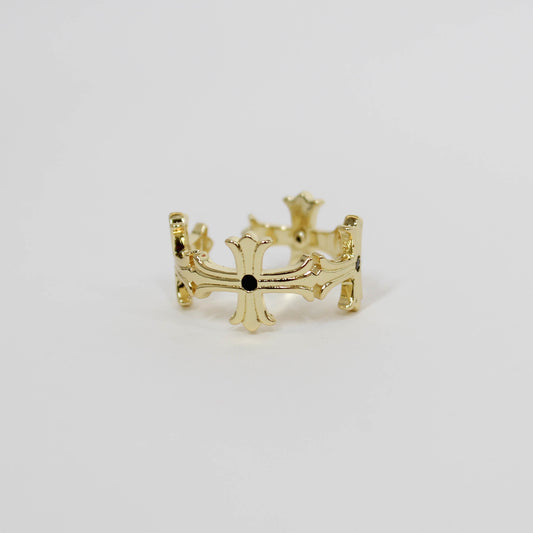 Gold cross ring with a black gemstone on a white background