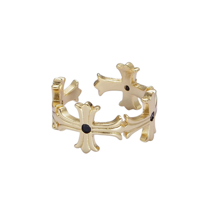 Gold cross-shaped ring with black stones on a white background
