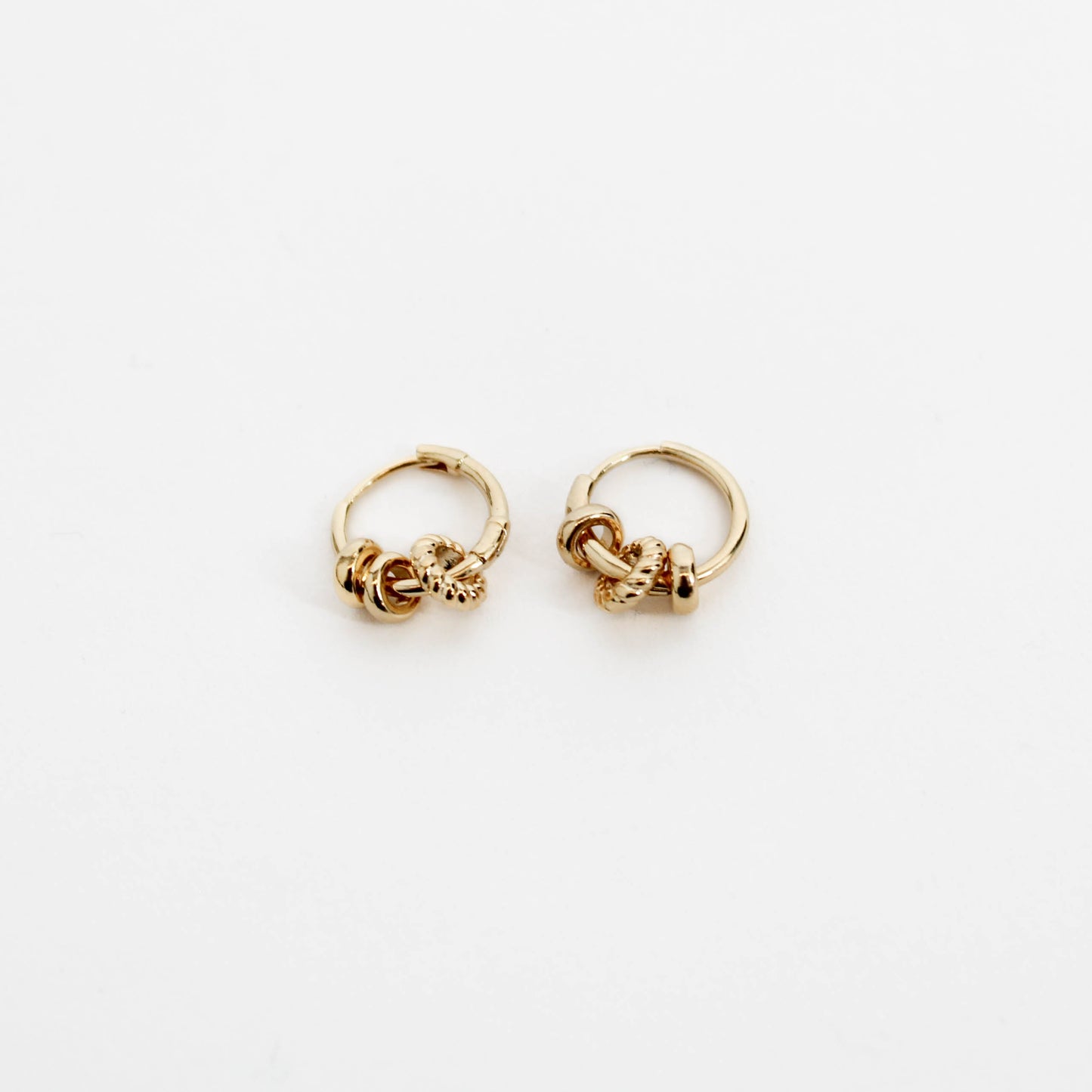 Pair of gold three ring hoop earrings on a white background