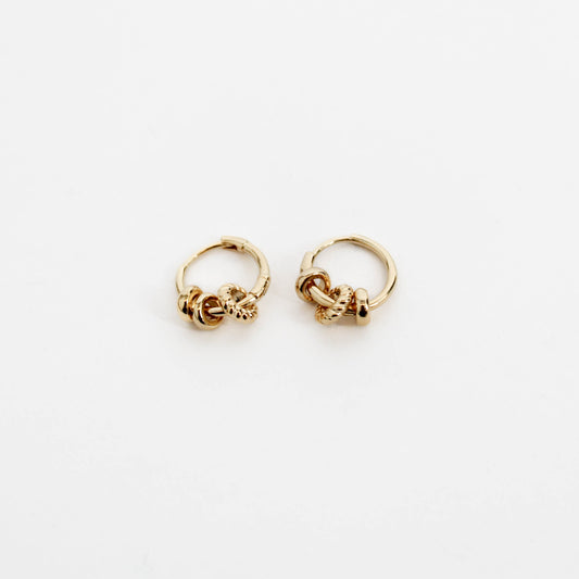 Pair of gold three ring hoop earrings on a white background