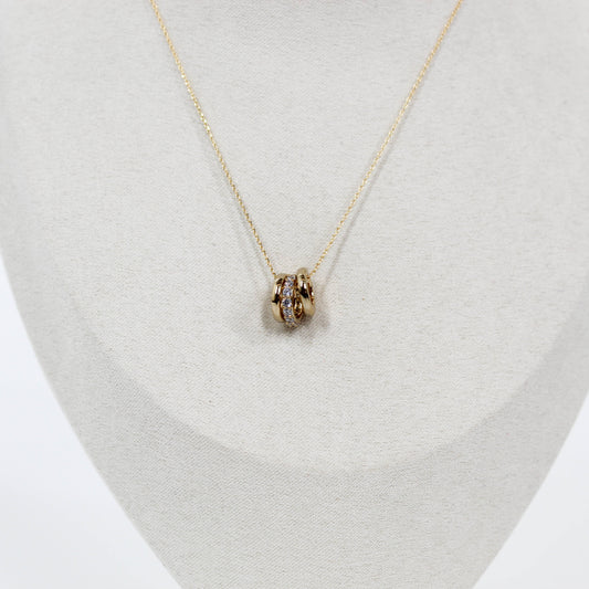 Gold three ring pendant necklace on a light gray stand