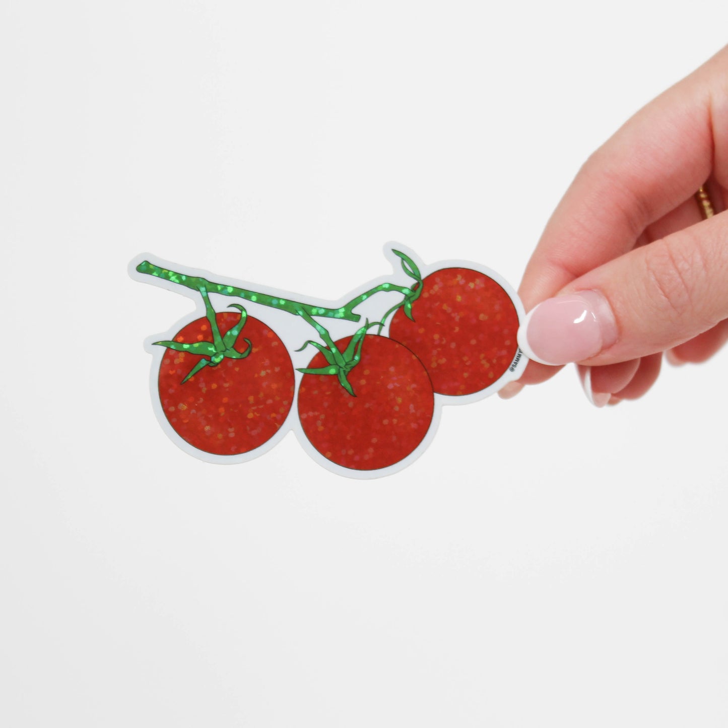 Three red tomatoes with green stems on a white background