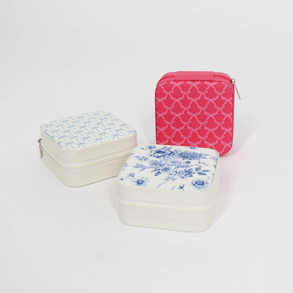 Three jewelry cases with floral and bow patterns on a white background